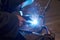 A man in a protective mask carries out welding work