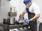 Man in protective mask and gloves frying tasty food