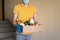 Man in protective mask and gloves holds box of food. Donation box with food supply, canned food, cereals, vegetables