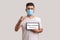 Man in protective mask holding Stay at home inscription and pointing to camera, warning of coronavirus quarantine