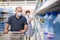 Man in protective mask picks water bottles on supermarket