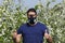 Man with protective mask while spraying cherry flowers