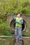 A man in a protective suit and a respirator in goggles performs an express analysis in the open air in an unfavorable area