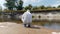 Man in a protective suit and respirator observes a chemical reaction of water in test tube