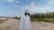 A man in a protective suit and a respirator stands among plastic trash