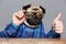 Man with pug dog head in glasses showing thumbs up