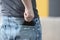 Man pulling out wallet from back pocket of jeans closeup