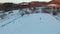 Man pulling sledge with two kids, mountain village, aerial view