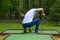 Man pulls the ball out of the pit to play mini-Golf, rear view