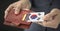 Man pulls credit card with flag of South Korea out of his wallet, fictional card number