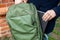 A man pulls a laptop out of his backpack. Universal city sports bag in khaki color. Macro photo.