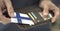 Man pulls plastic card with flag of Finland out of his wallet, fictional card number