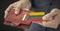 Man pulls plastic card with flag of Lithuania out of his wallet, fictional card number