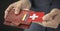 Man pulls plastic card with flag of Switzerland out of his wallet, fictional card number