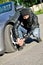 Man punctures a car tyre.