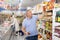 Man purchaser choosing tomato juice in big supermarket