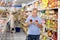 Man purchaser choosing tomato juice in big supermarket