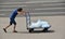 A man pushes a cart with ice packs during a record hot day.