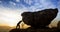 Man pushing a boulder on a rock