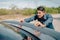 Man pushing a broken car breakdown on the road hot day. Car broken concept