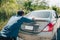 Man pushing a broken car breakdown on the road hot day. Car broken concept