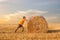 A man pushing a straw bale