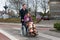 Man pushing a woman in a wheelchair at a zebra crosssing