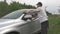 Man puts bucket on ground and starts washing automobile