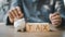 Man puts coin in a piggy bank with a wooden cube text Tax personal income tax.