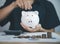 man puts coins in pig piggy bank. concept of Saving bank accounts and investing funds to maximize profits. Growing business