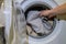 A man puts dirty laundry in a washing machine