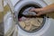 A man puts dirty laundry in a washing machine