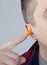 The man puts on earplugs. Close-up of an orange noise barrier. Deep sleep. The ENT doctor advises orange earmuffs to reduce