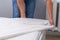 A man puts an elasticated sheet on mattress. Change of bed linen.