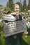 A man puts his hands around a cutout of George W. Bush saying Mission Accomplished at an anti-Iraq War protest march in Santa Barb