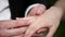 A man puts his woman a wedding ring on the finger. Close up macro