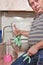 A man puts on household rubber gloves to wash a dirty toilet