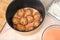 A man puts lazy cabbage rolls into multicooker bowl and pours tomato and sour cream sauce over them.