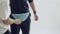 Man puts on light blue fanny pack on hips of male model