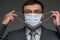 A man puts a mask on his face for antivirus individual protection - healthcare and medicine concept, prevention tips