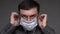 A man puts a mask on his face for antivirus individual protection - healthcare and medicine concept, prevention tips