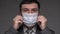 A man puts a mask on his face for antivirus individual protection - healthcare and medicine concept, prevention tips