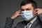 A man puts a mask on his face for antivirus individual protection - healthcare and medicine concept, prevention tips