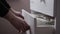 A man puts one baby diaper in a chest of drawers, close-up