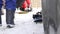 Man puts on shoes for snowboarding near the car on a mountain parking