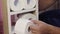 A man puts toilet paper on a homemade shelf. Making furniture at home. Close-up shot