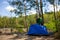 A Man Puts Up A Tent On The Site Of A Future Camp In The Forest