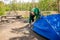 A Man Puts Up A Tent On The Site Of A Future Camp In The Forest