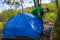 A Man Puts Up A Tent On The Site Of A Future Camp In The Forest