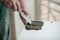 A man putsglue with putty knife on foam to stick it to the ceiling. Styrofoam, seiling mounting.